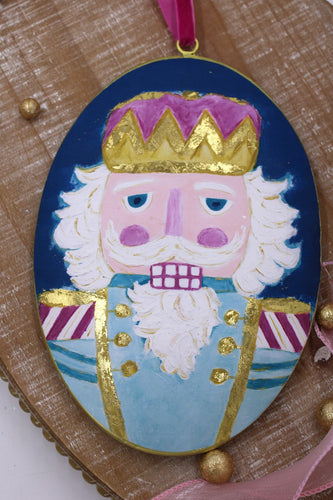 Oval Metal Disc Ornament Nutcracker with Gold Accents 6x9’’